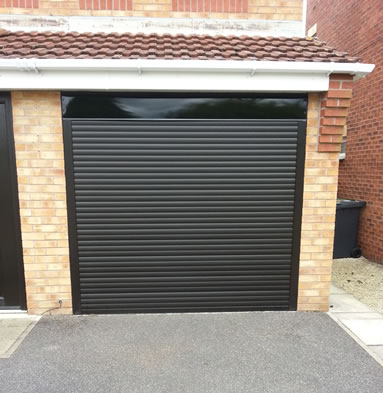 A black garage door on rollers
